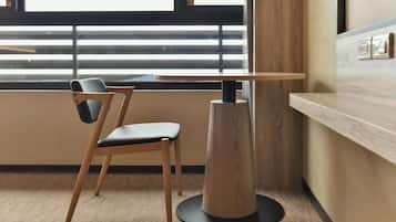 A modern room with a wooden chair and a round table.
