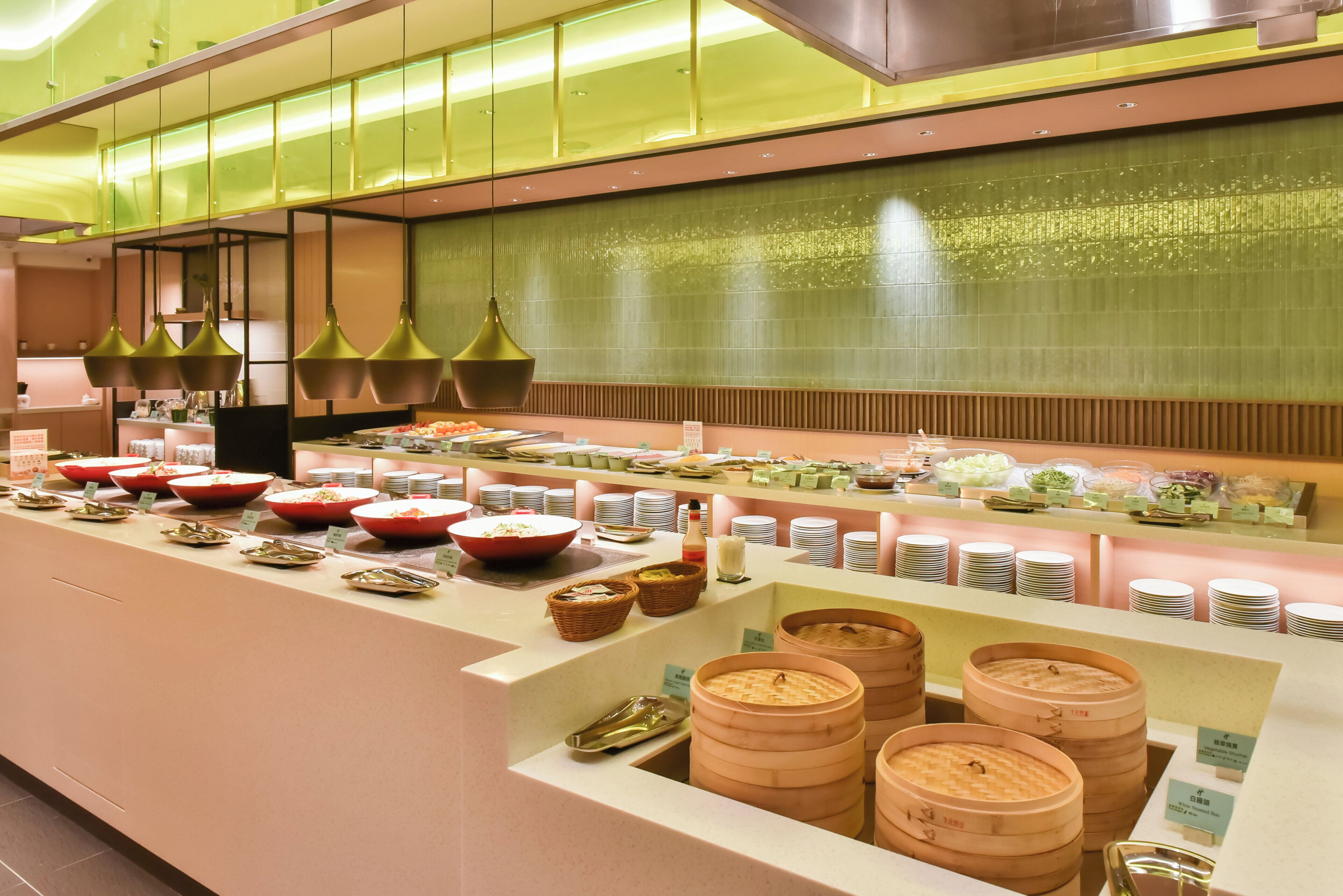 Uma área de buffet com diversos alimentos e recipientes, incluindo tigelas, pratos e cestos.