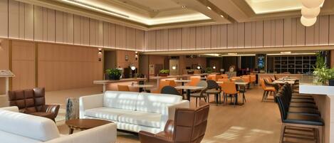 A spacious lobby with seating areas, a reception desk, and a large window.