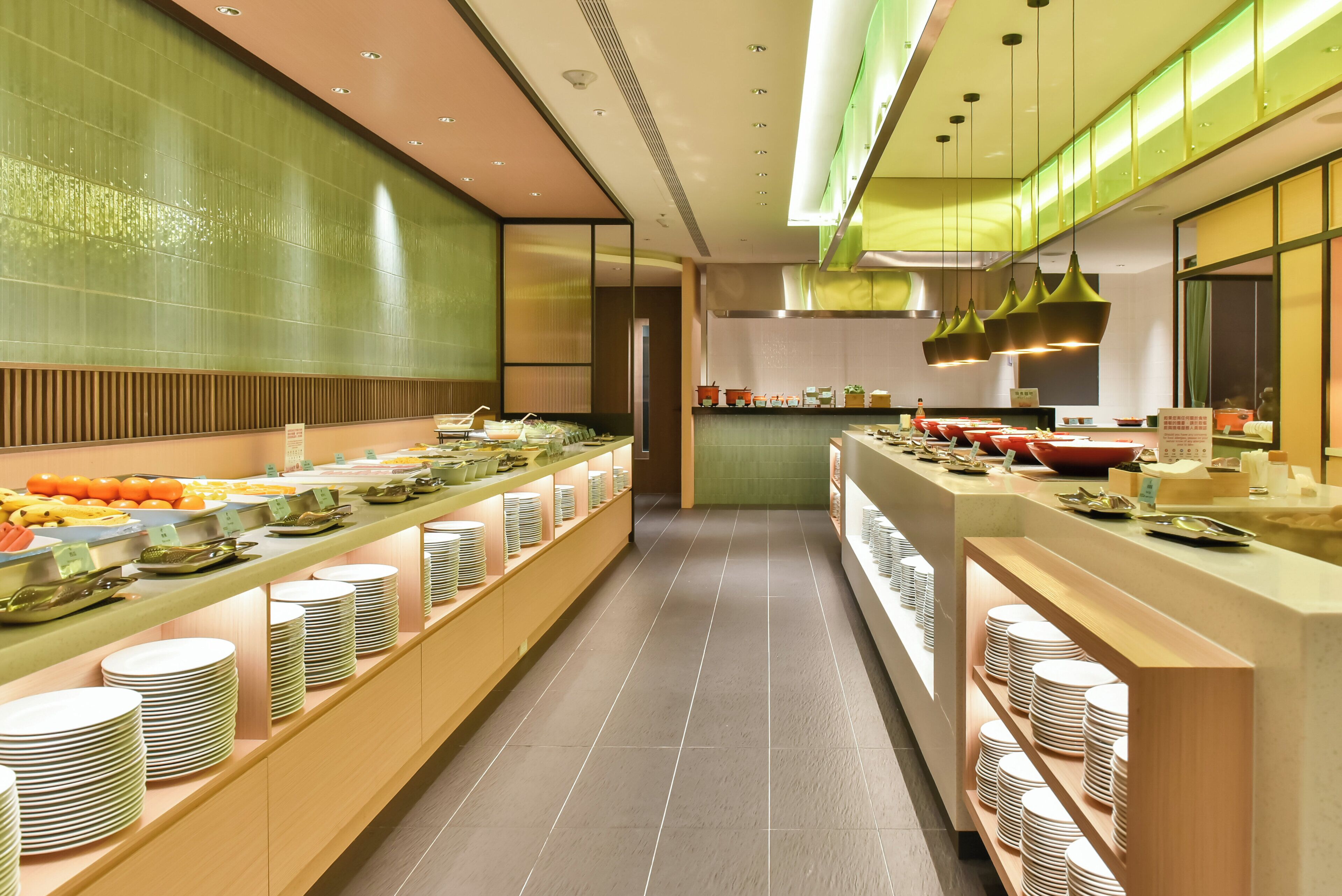 A modern kitchen with a long counter displaying various dishes and utensils.