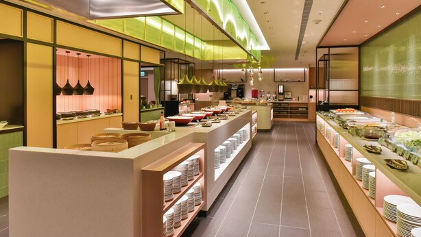 Una moderna presentación tipo buffet con varias estaciones de servicio, una isla central y un diseño limpio y contemporáneo.