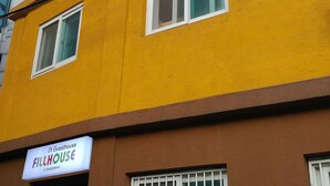 A building with a yellow facade and multiple windows. There is a sign that reads "Guesthouse Fillhouse in Dongdaemun." - FILL HOUSE (Seoul)
