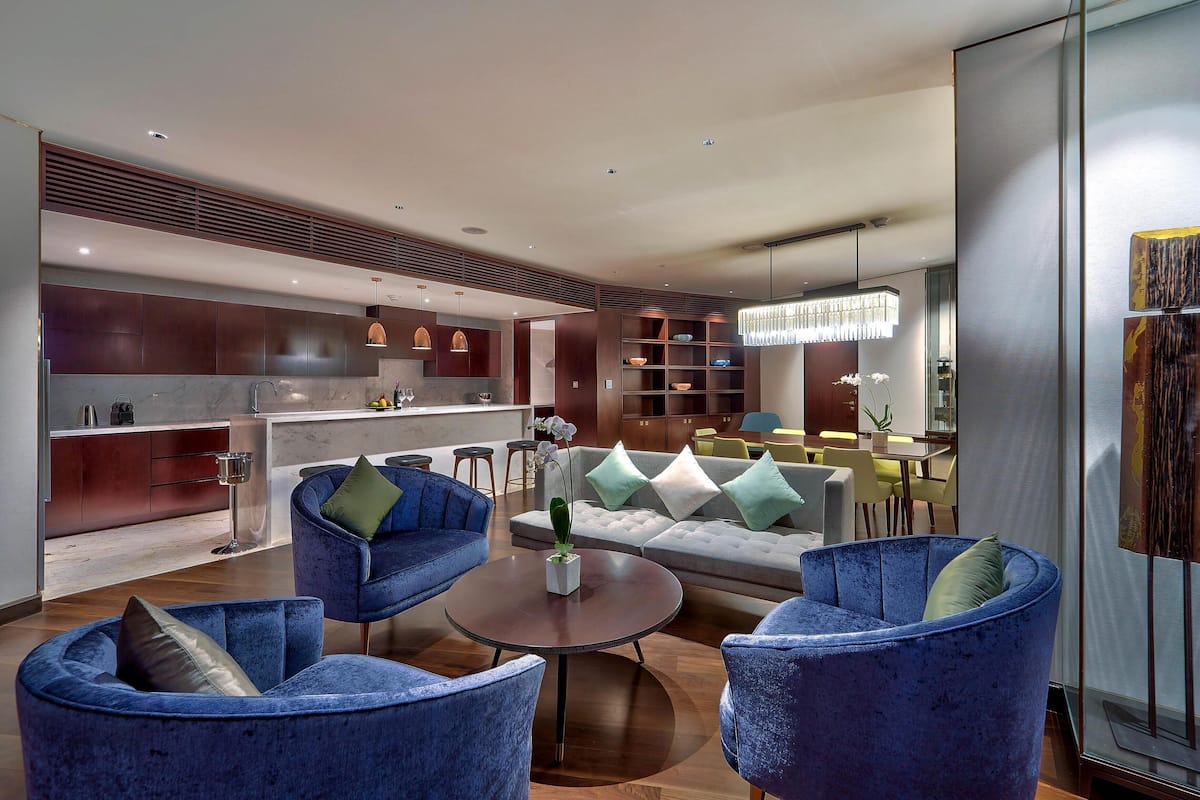 A modern living room with a sofa, armchairs, and a coffee table.