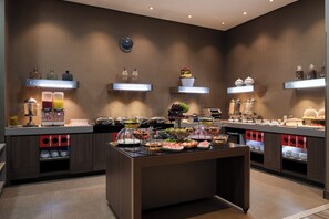 Una mesa de buffet con diversos alimentos y aderezos.