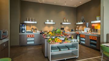 A modern kitchen with a central island stocked with fruits and vegetables, a coffee machine, and various kitchen appliances.