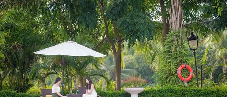 Relax by the pool surrounded by lush greenery and tranquil ambiance.
