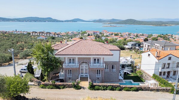 A two-story house with a tiled roof, a front entrance, and a swimming pool. - Cunda Piano Otel (Ayvalik)