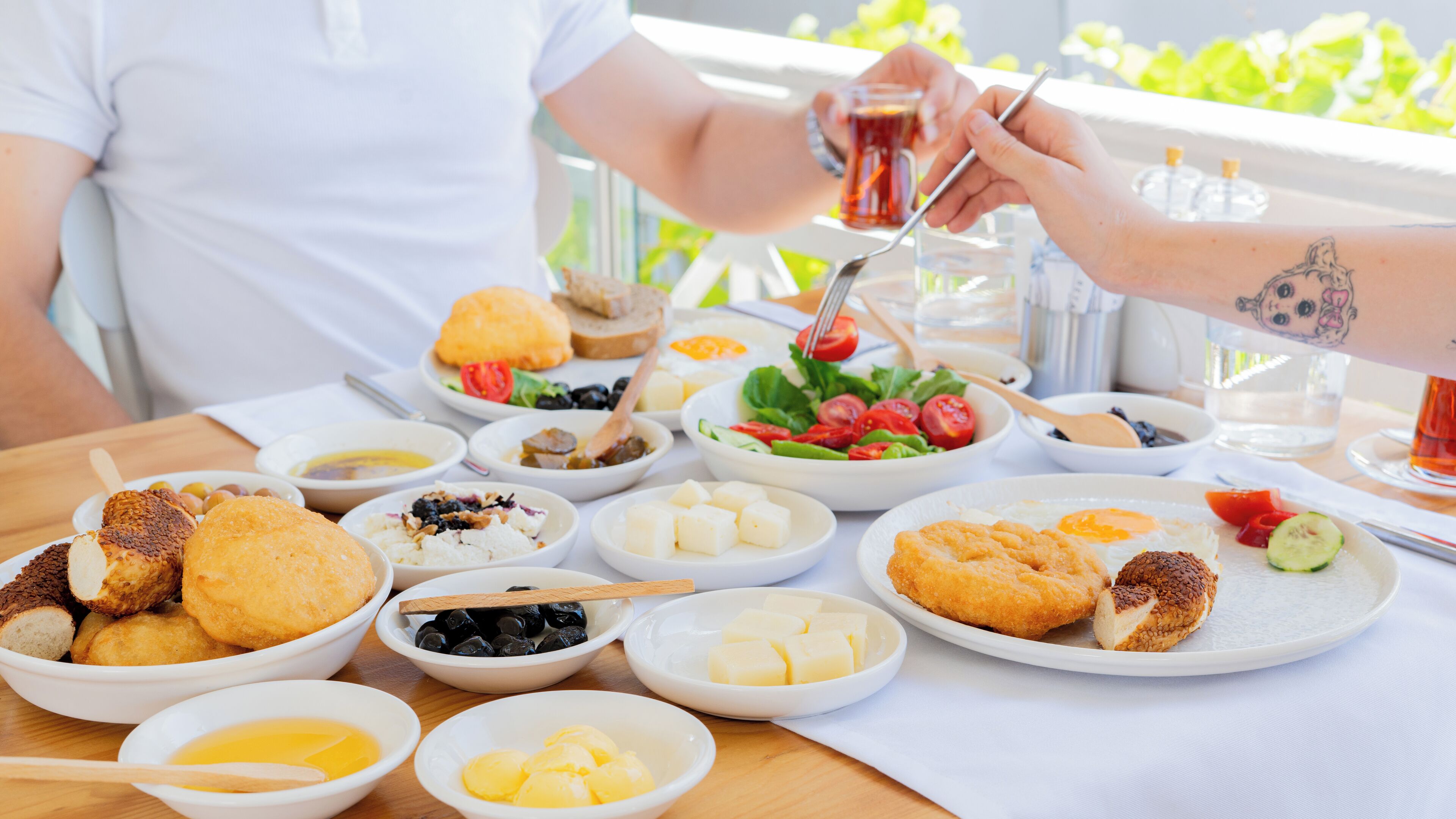 A table set with various dishes including bread, cheese, and a salad, suggesting a meal setting.