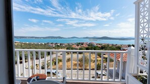 A balcony with a view of a coastal town, a clear sky, and distant mountains. - Cunda Piano Otel (Ayvalik)