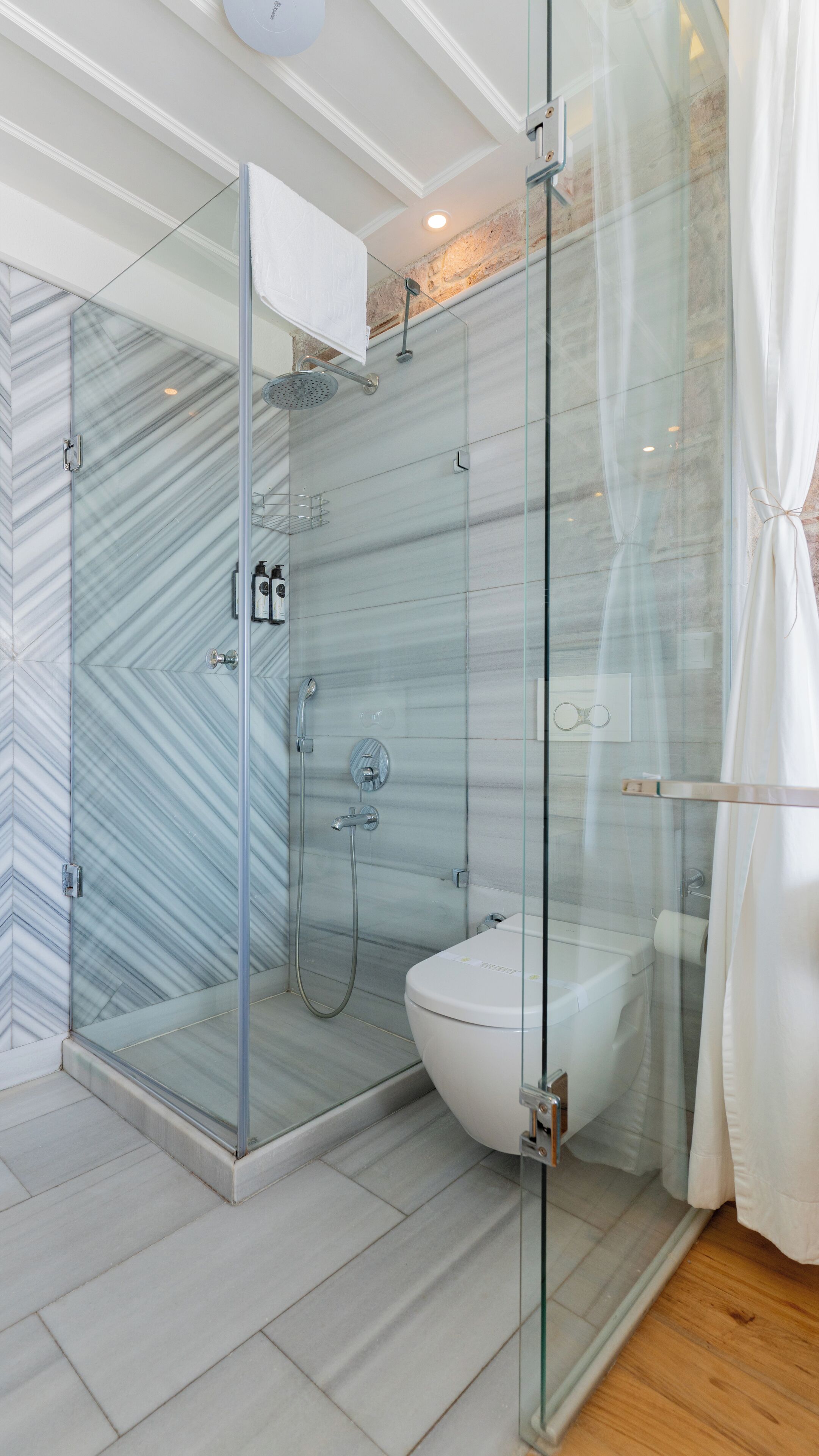 Un baño moderno con ducha envuelta en vidrio, inodoro y lavamanos.
