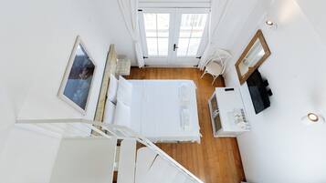 Ein Schlafzimmer mit Bett, Nachttisch und Fenster.