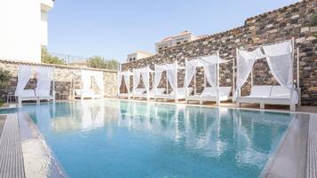 Alberca al aire libre, sombrillas en la alberca y camastros