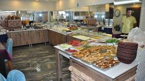 Montaje de bufé con diversas opciones de comida y una estación de café.