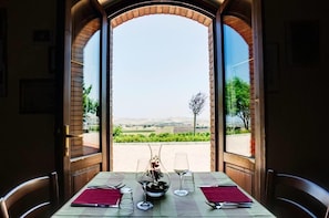 A table set for two with a view of a vineyard through an open archway. - Relais I Dolci Grappoli (Larino)