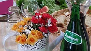 A table set for a meal with a bottle of Audianello wine, a pitcher of water, and a vase of flowers. - Relais I Dolci Grappoli (Larino)