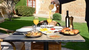 A table set outdoors with food, drinks, and a bottle of wine. - Hotel Molí de l'Escala (L'Escala)