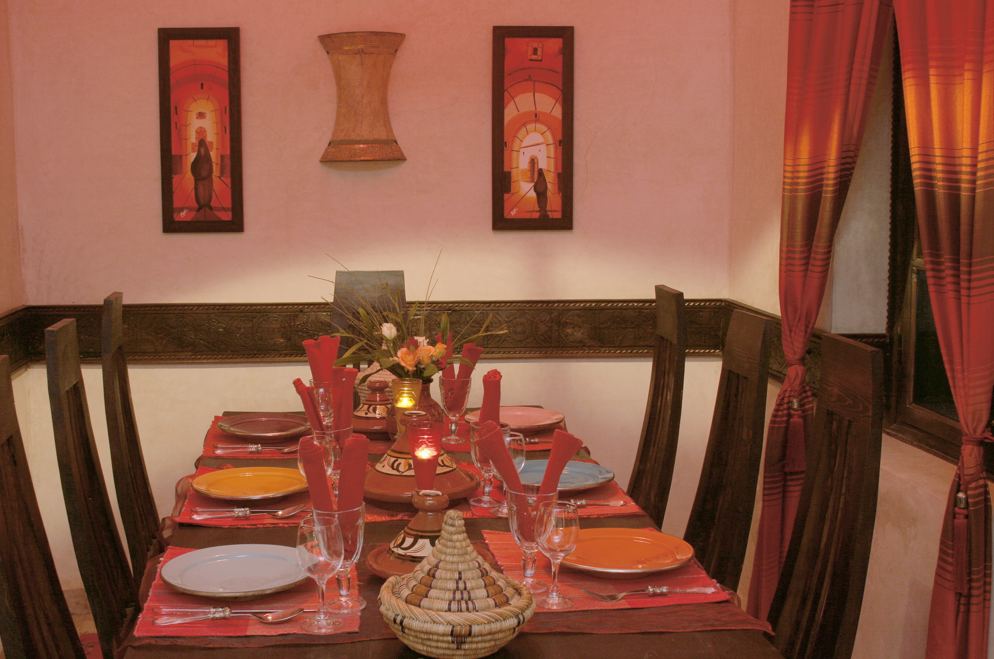 A dining table set with plates, glasses, and a centerpiece.