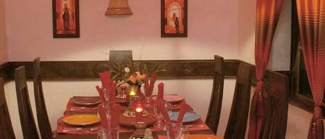 A dining table set with plates, glasses, and a centerpiece.
