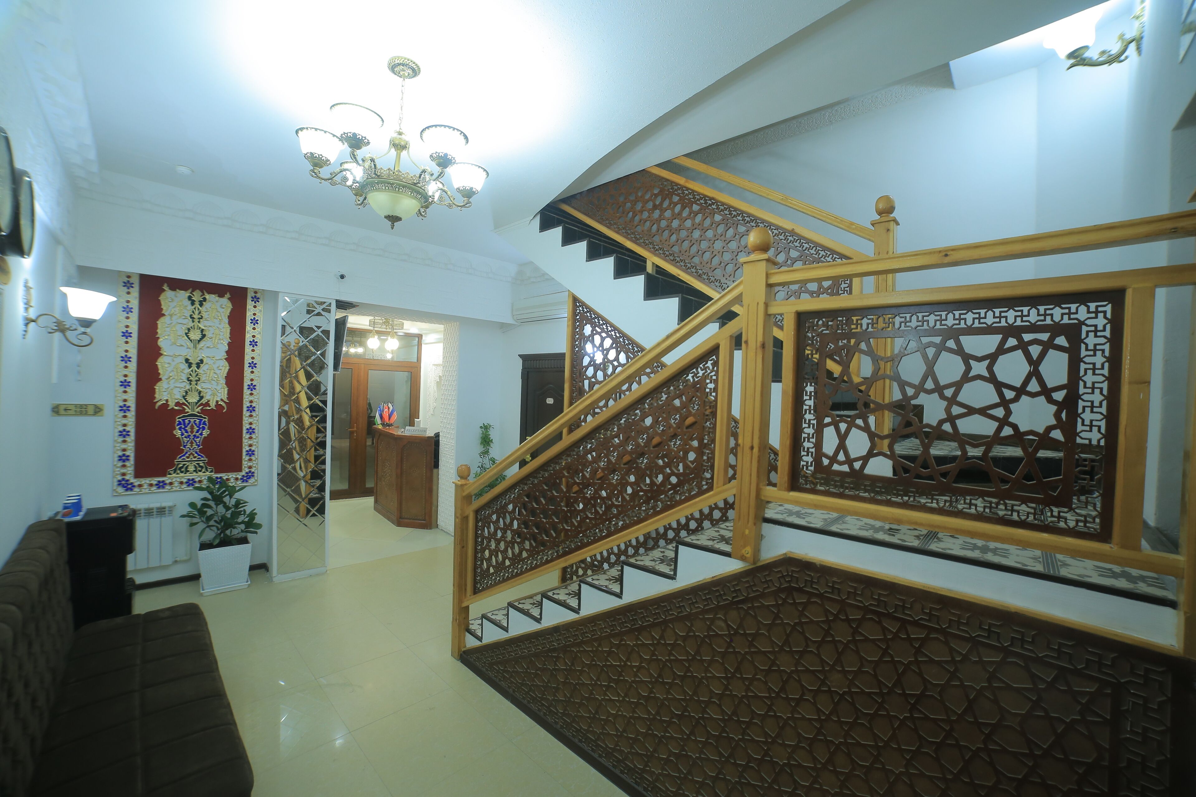 A staircase with intricate wooden railings and a chandelier.