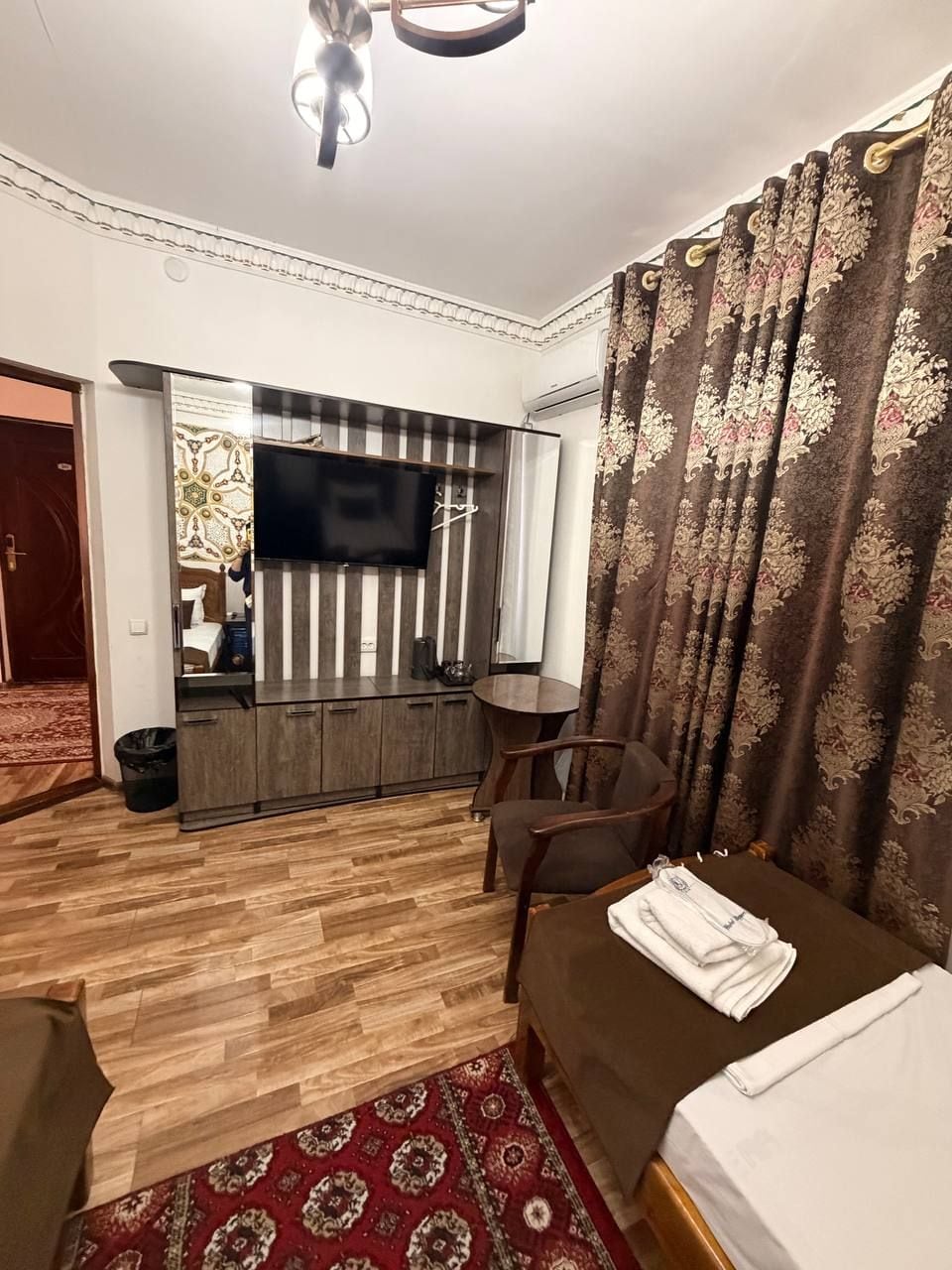 A hotel room with a bed, a TV, a desk, and a chair.