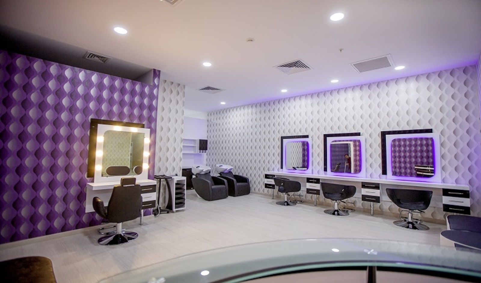 Ein moderner Friseursalon mit mehreren Styling-Plätzen, jeweils ausgestattet mit Spiegel und Friseurstuhl.