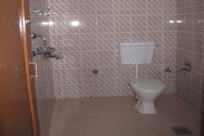 A small bathroom with a toilet, a sink, and a shower. - Hotel Green Orchid (Kathmandu)