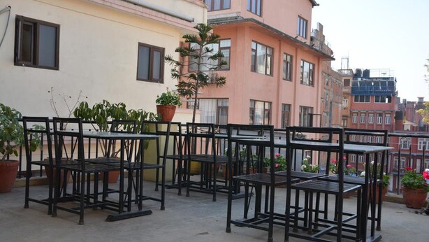 A rooftop terrace with outdoor seating and potted plants. - Hotel Green Orchid (Kathmandu)