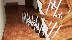 A wooden staircase with white balusters and a wooden handrail. - Hotel Green Orchid (Kathmandu)