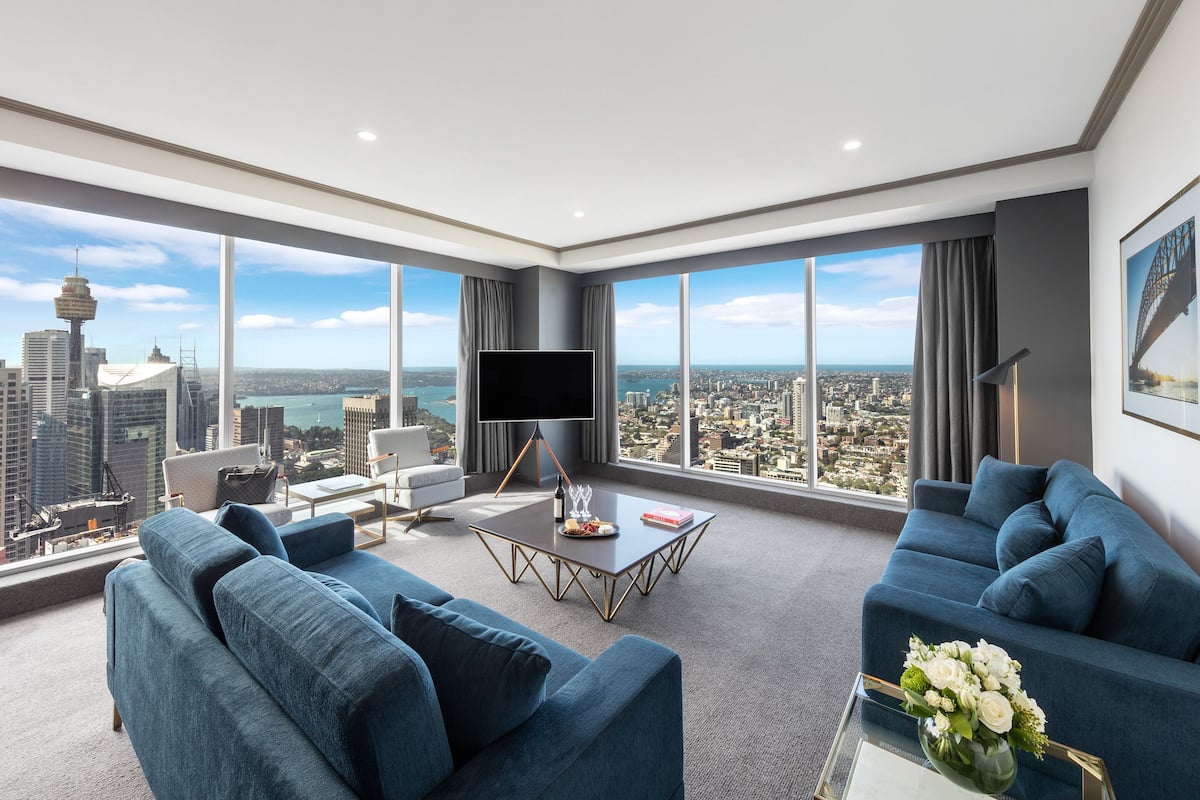A modern living room with a city view, a flat-screen TV, and a coffee table.