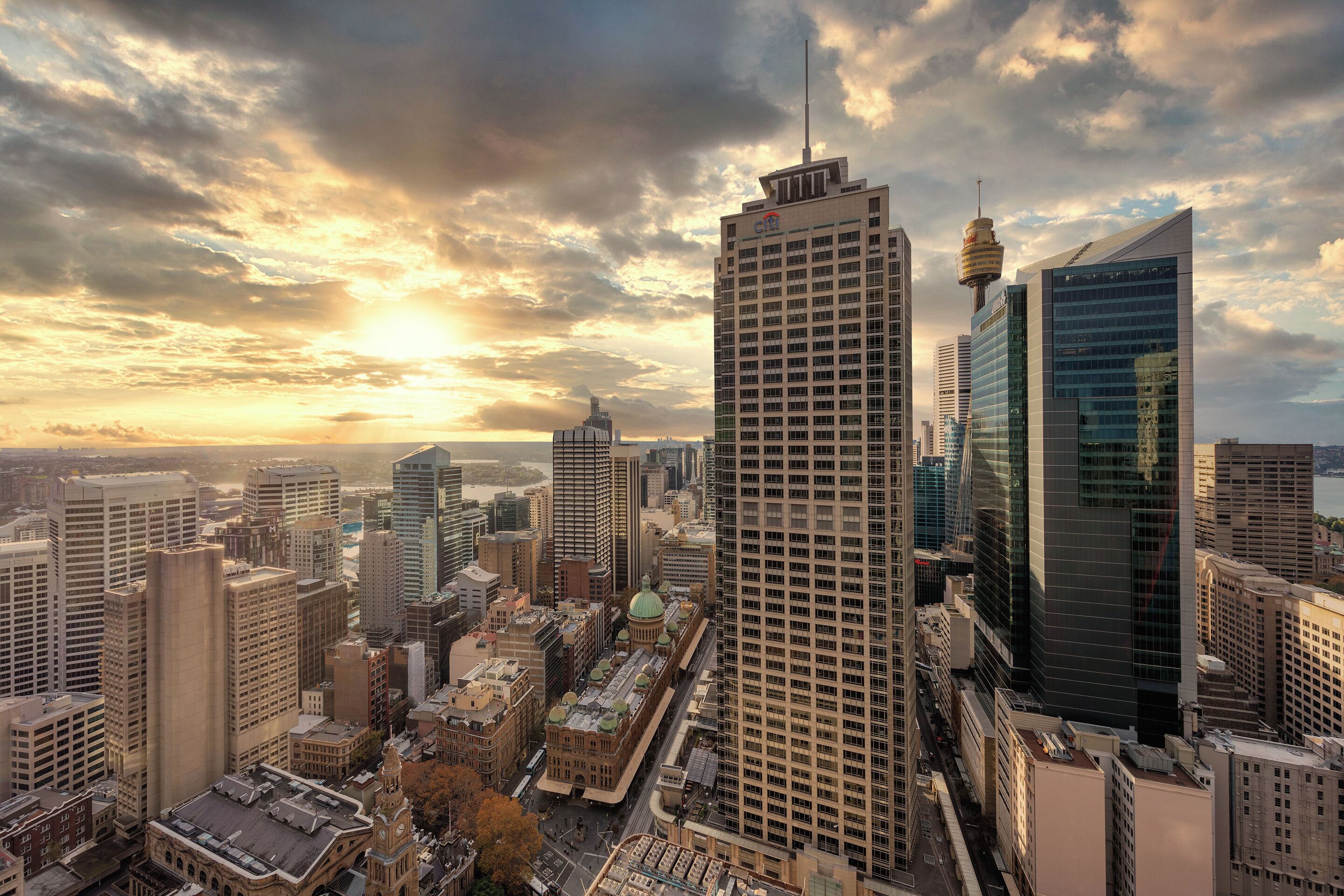 A cityscape with modern skyscrapers, a prominent tower, and a historic building with a dome.