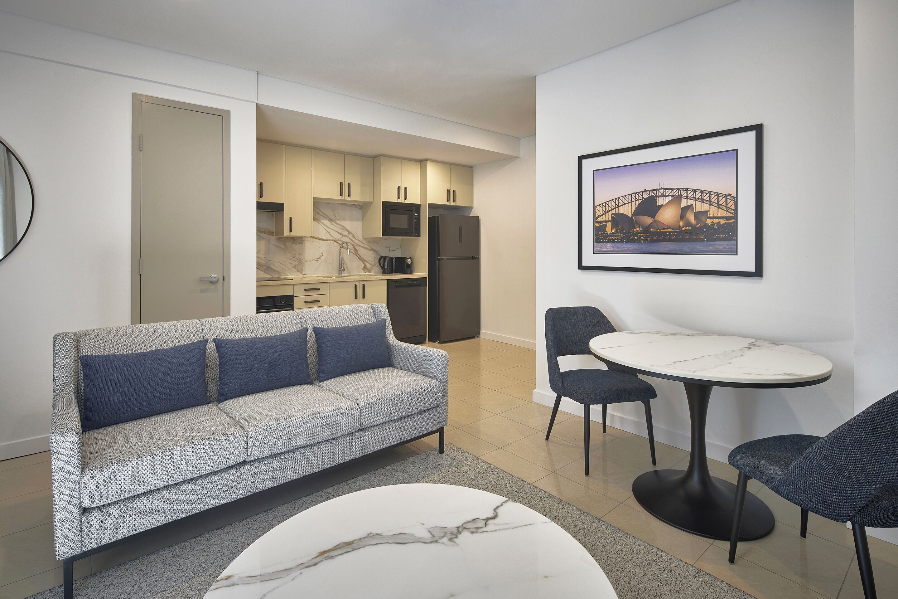 Una sala de estar moderna con un sofá, una mesa de centro y un comedor con sillas y una mesa.