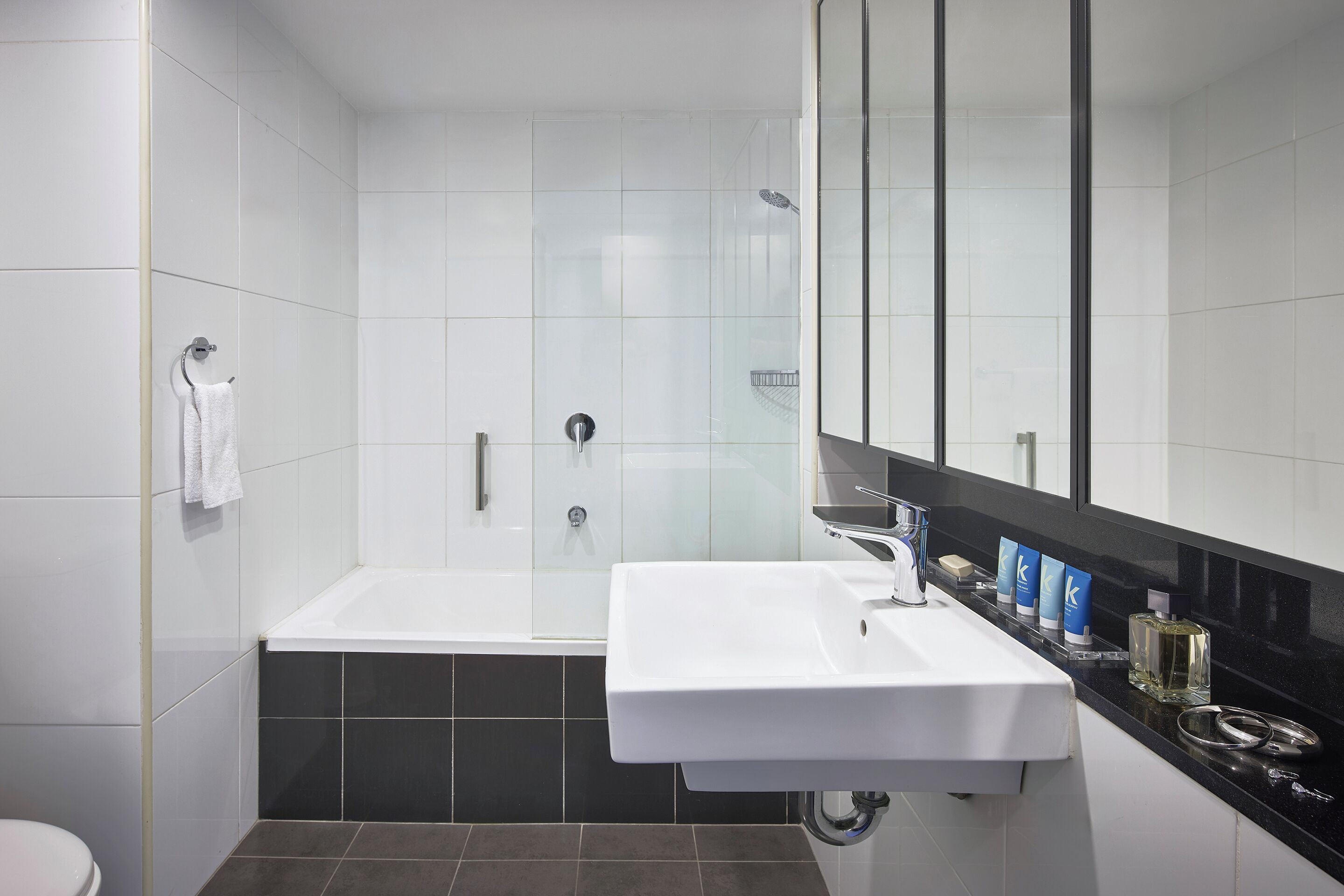 A modern bathroom with a bathtub, a sink, and a glass shower enclosure.
