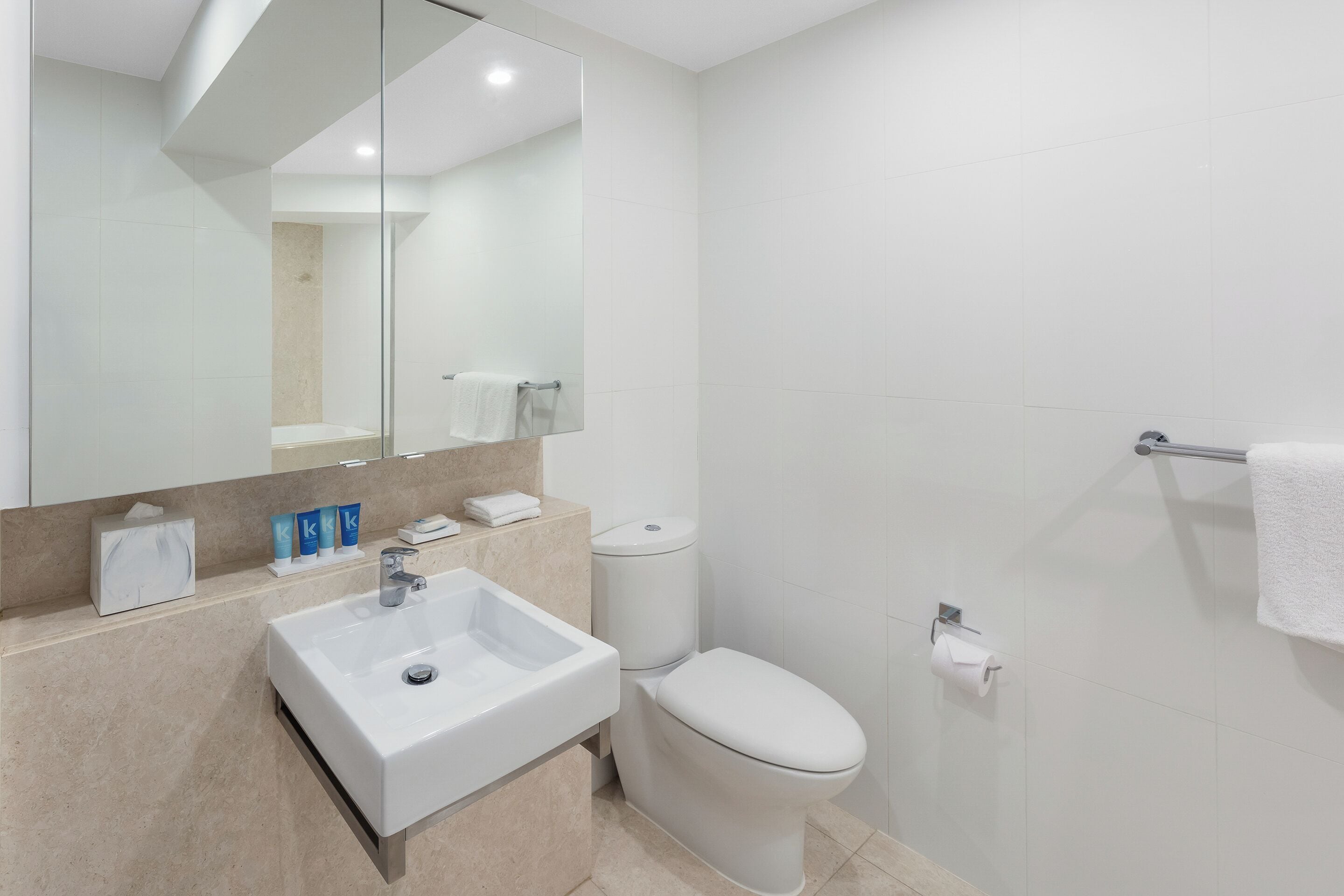 A modern bathroom with a sink, toilet, and shower area.