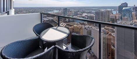 Een balkon met rieten meubilair en een helder uitzicht op de stad.