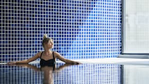 A person in a swimming pool with a tiled wall in the background. - Meriton Suites Kent Street, Sydney (Sydney)