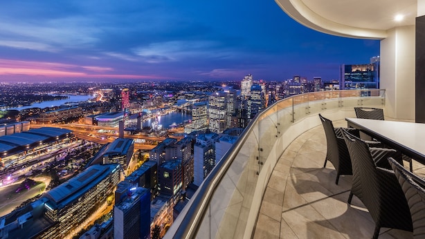 A high-rise balcony with a city view, modern furniture, and a glass railing. - Meriton Suites Kent Street, Sydney (Sydney)