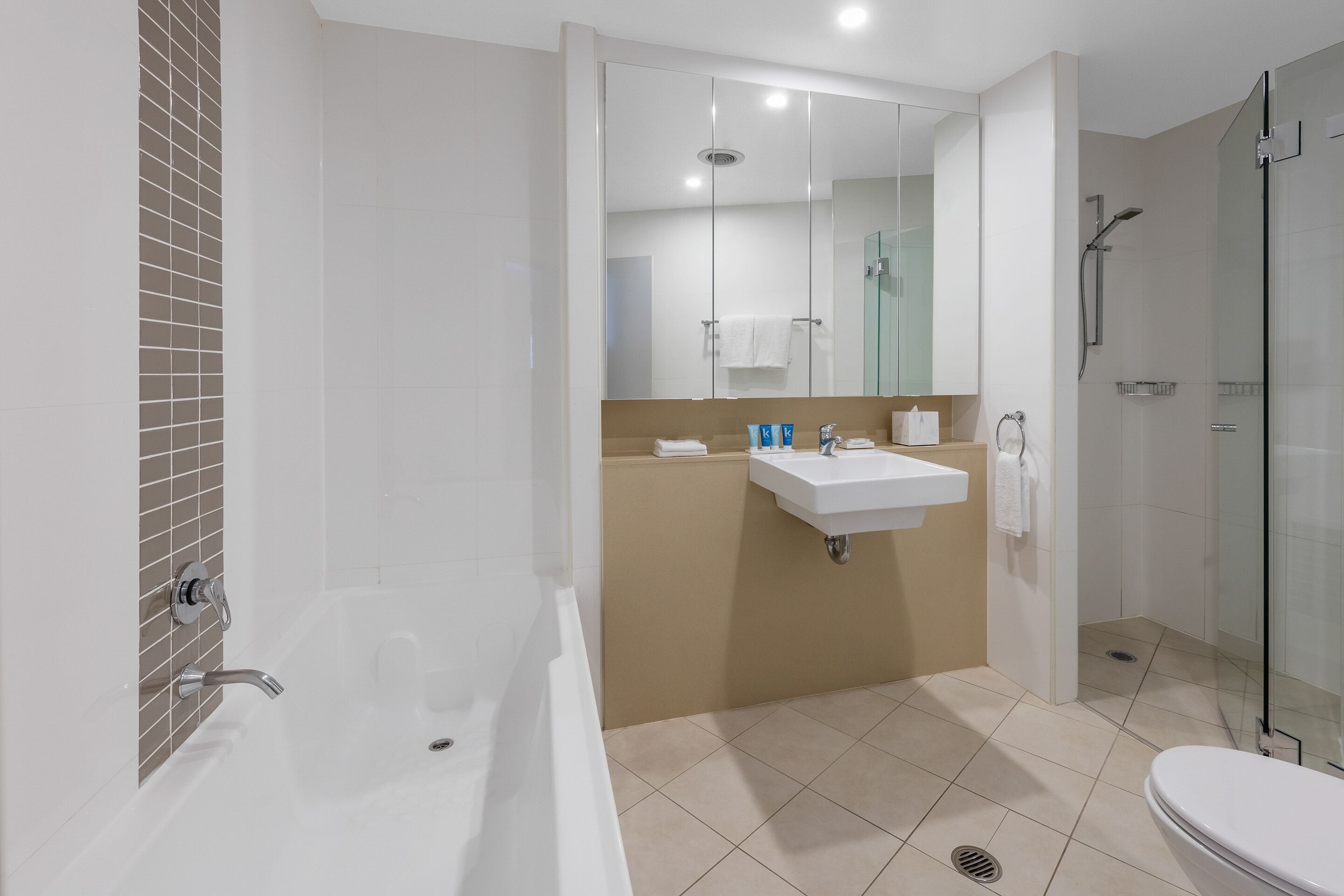 A modern bathroom with a bathtub, sink, and shower.