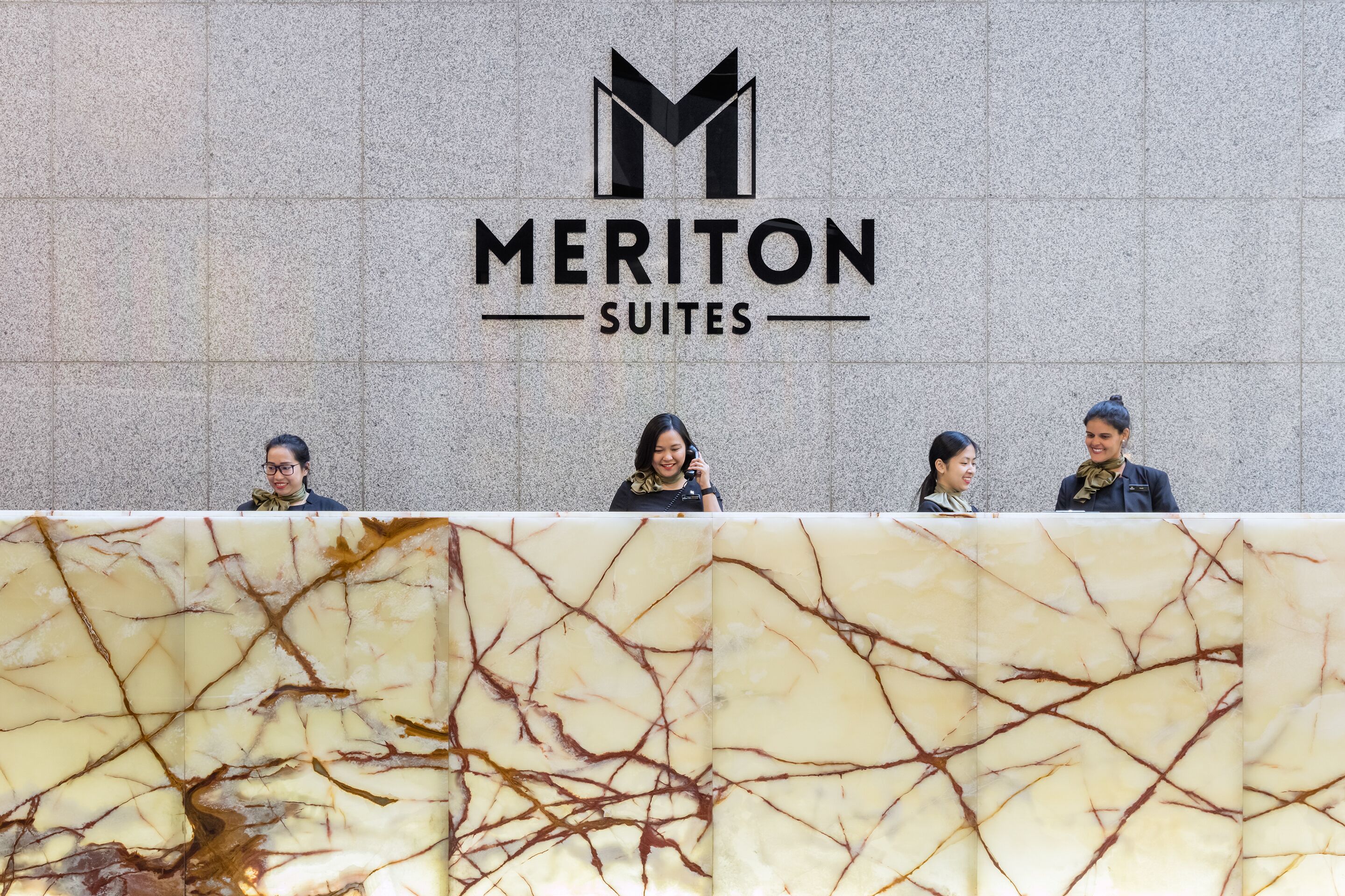 Une enseigne d’hôtel portant le nom « Meriton Suites ».