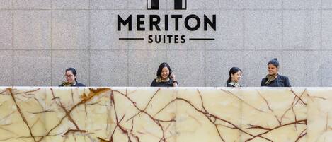 Une enseigne d’hôtel portant le nom « Meriton Suites ».