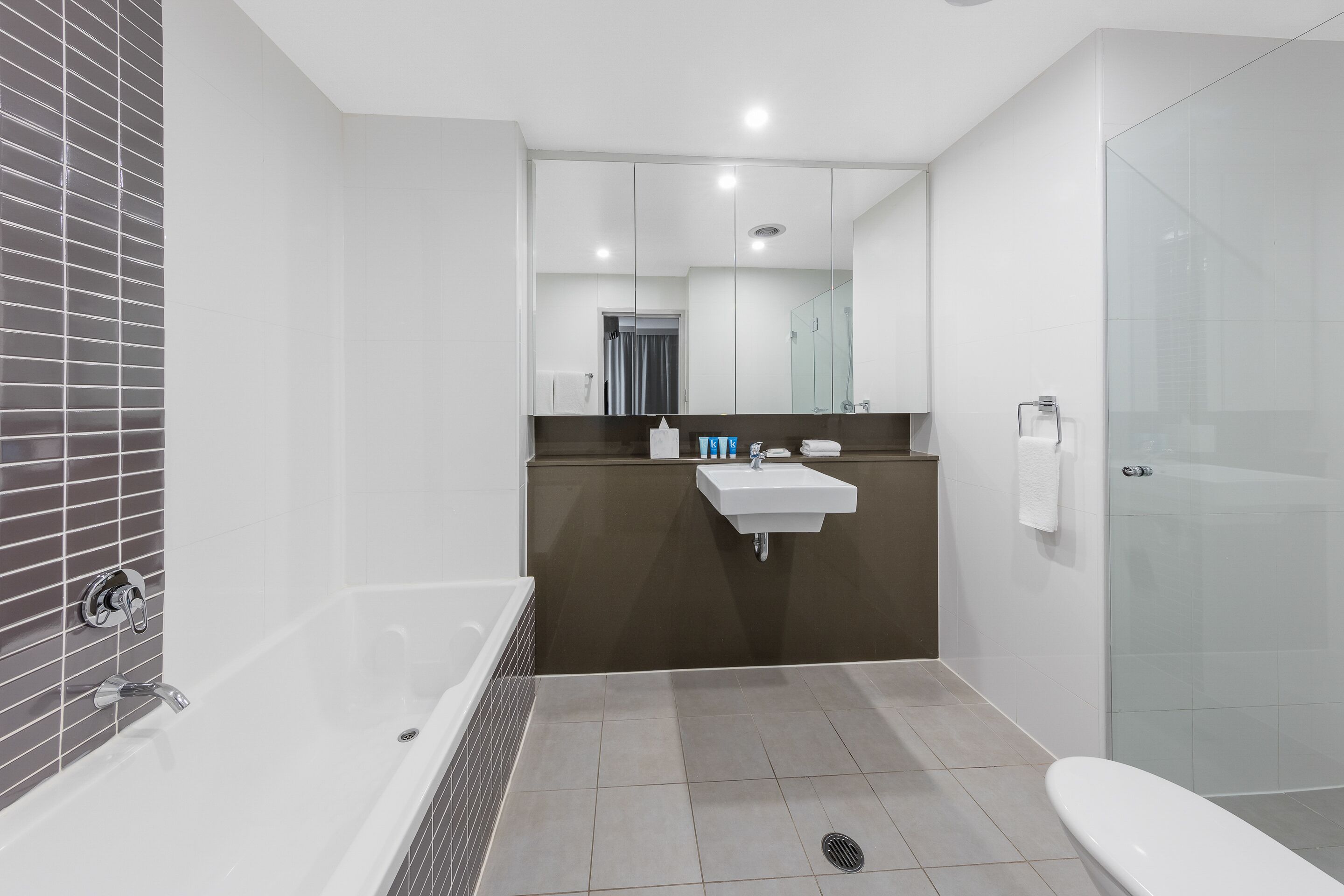 Een moderne badkamer met een bad, een wastafel en een douchehoek.