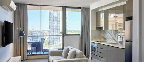 Suíte, 1 quarto, sacada (Sky) | Área de estar | TV de tela plana 50 polegadas com canais digitais, serviços de streaming