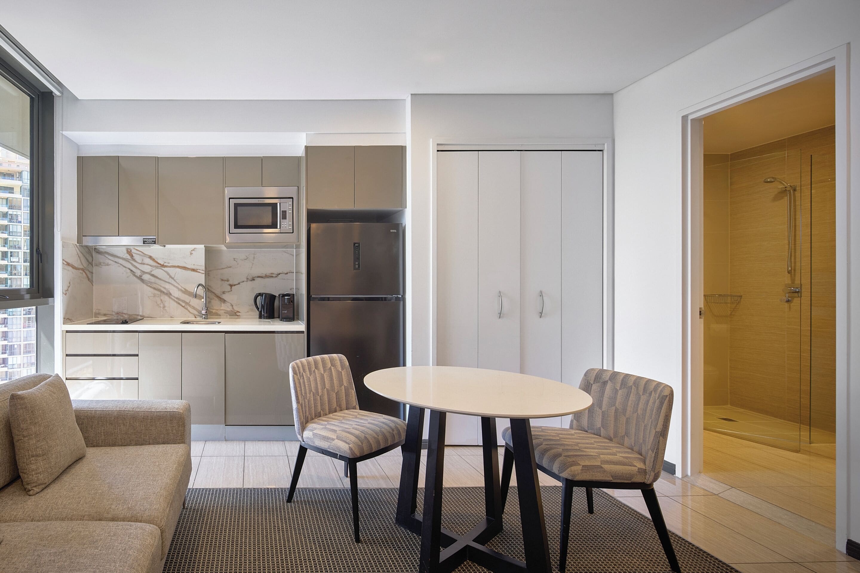 Cocina moderna con comedor, sofá y cuarto de baño.