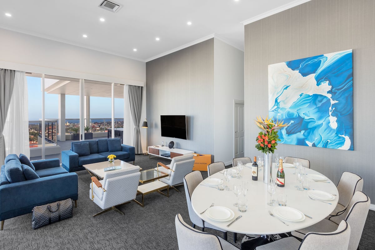 Une chambre d’hôtel moderne dotée d’un grand balcon, d’un coin repas et d’un espace de vie.