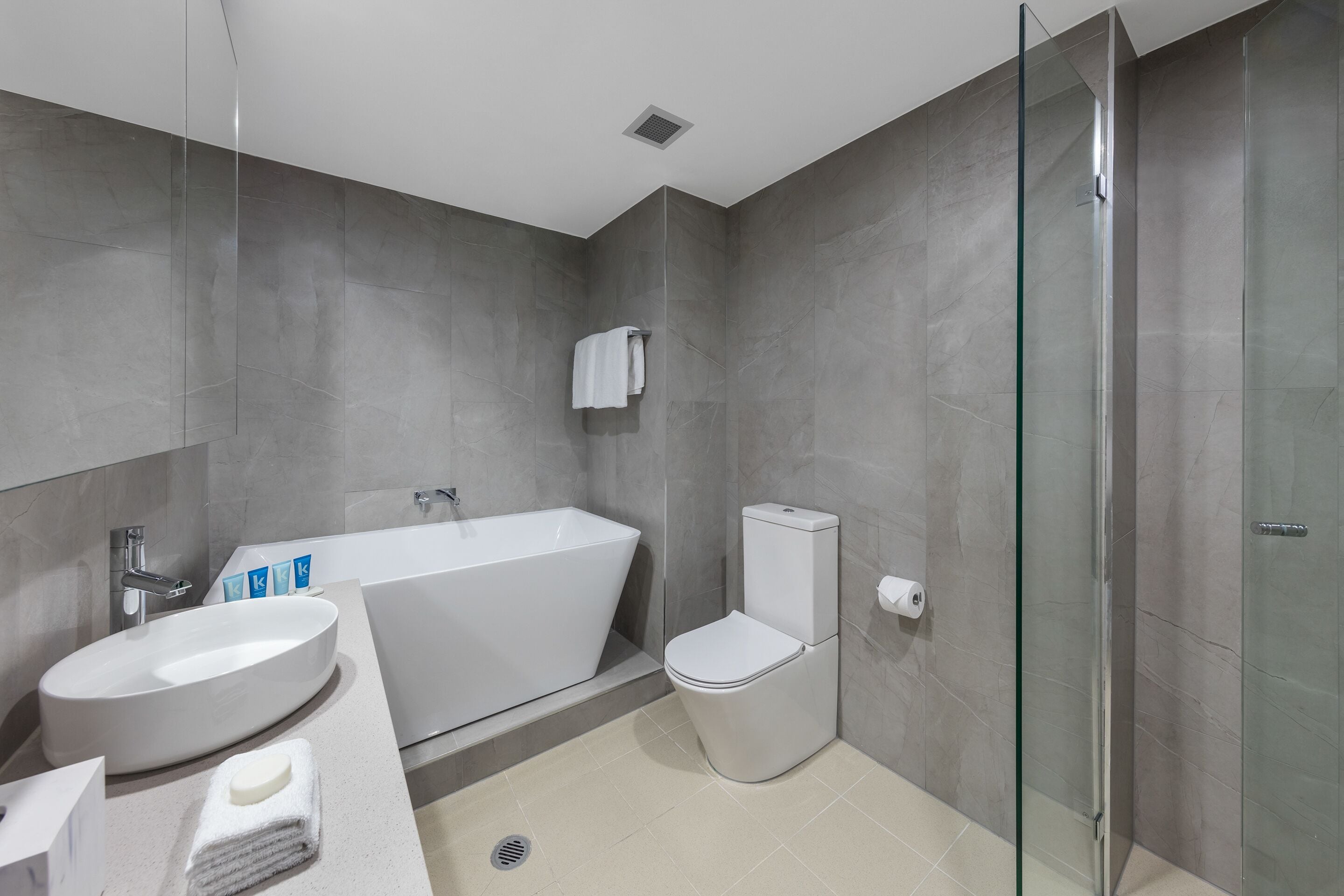 A modern bathroom with a freestanding bathtub, a toilet, and a glass shower enclosure.