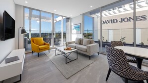 A modern living room with a sofa, yellow armchair, and a dining table. - Meriton Suites Bondi Junction (Bondi Junction)