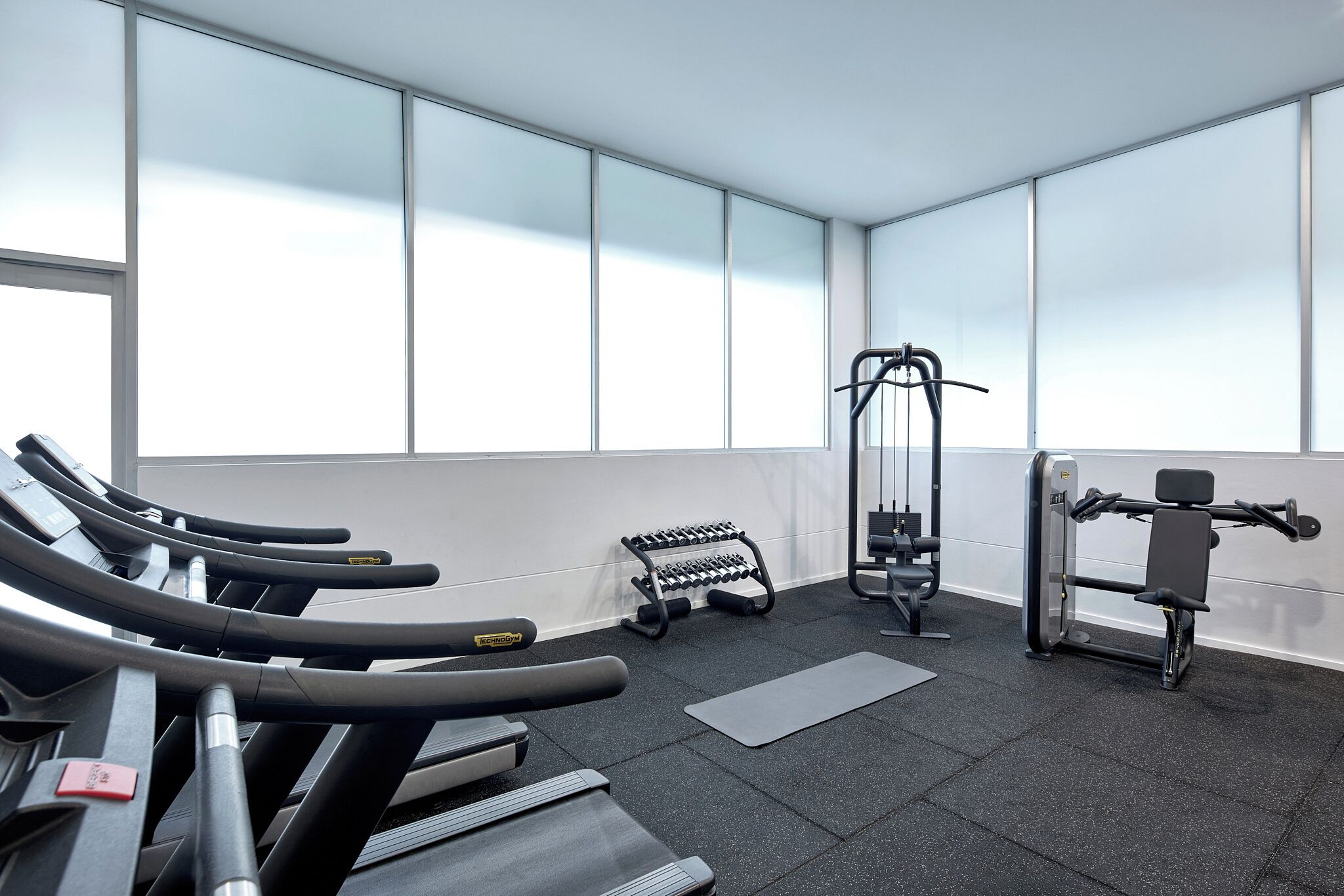 Et fitnesscenter med løbebånd, håndvægte og styrkemaskiner.