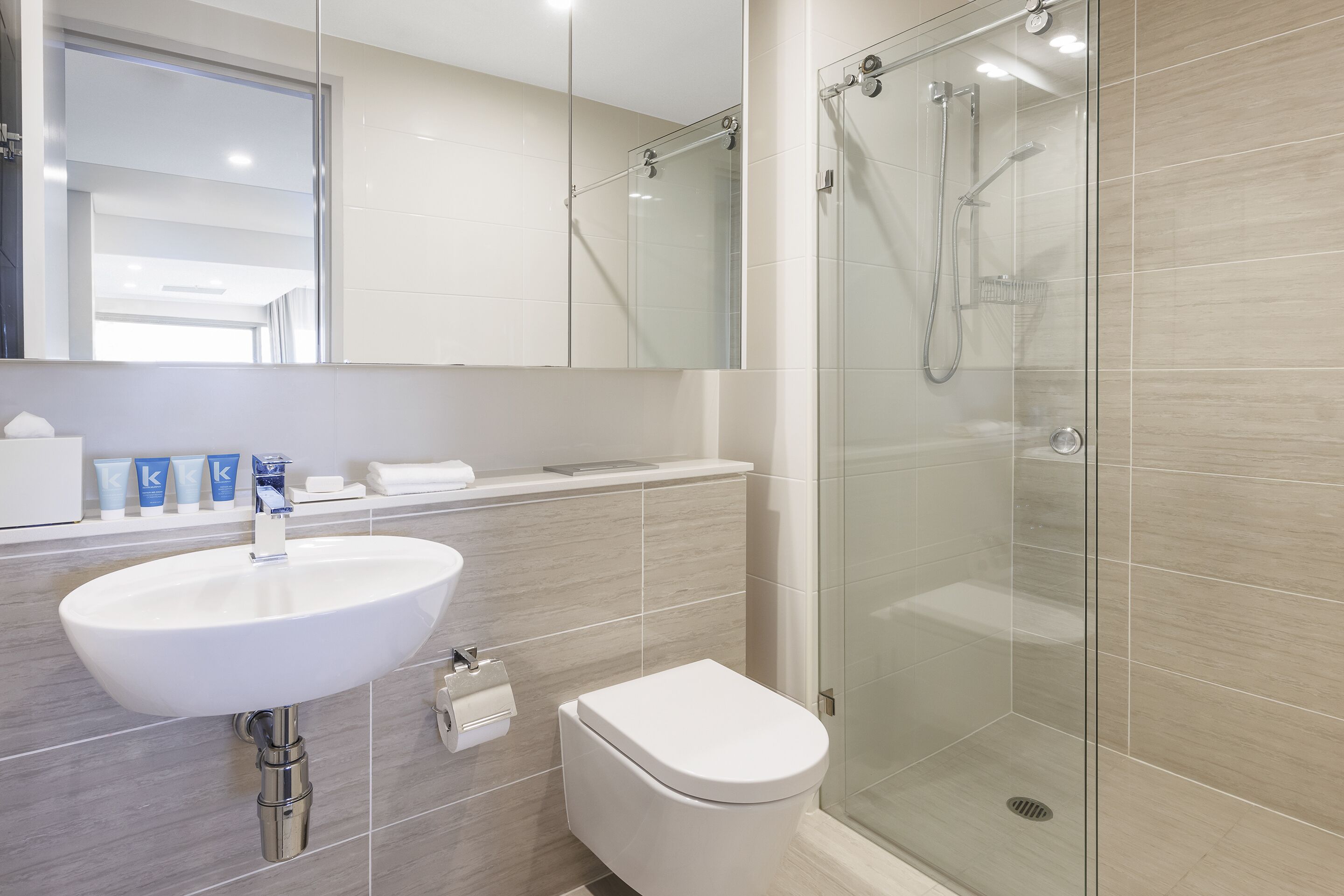 Ein modernes Badezimmer mit Waschbecken, Toilette und einer Duschkabine.