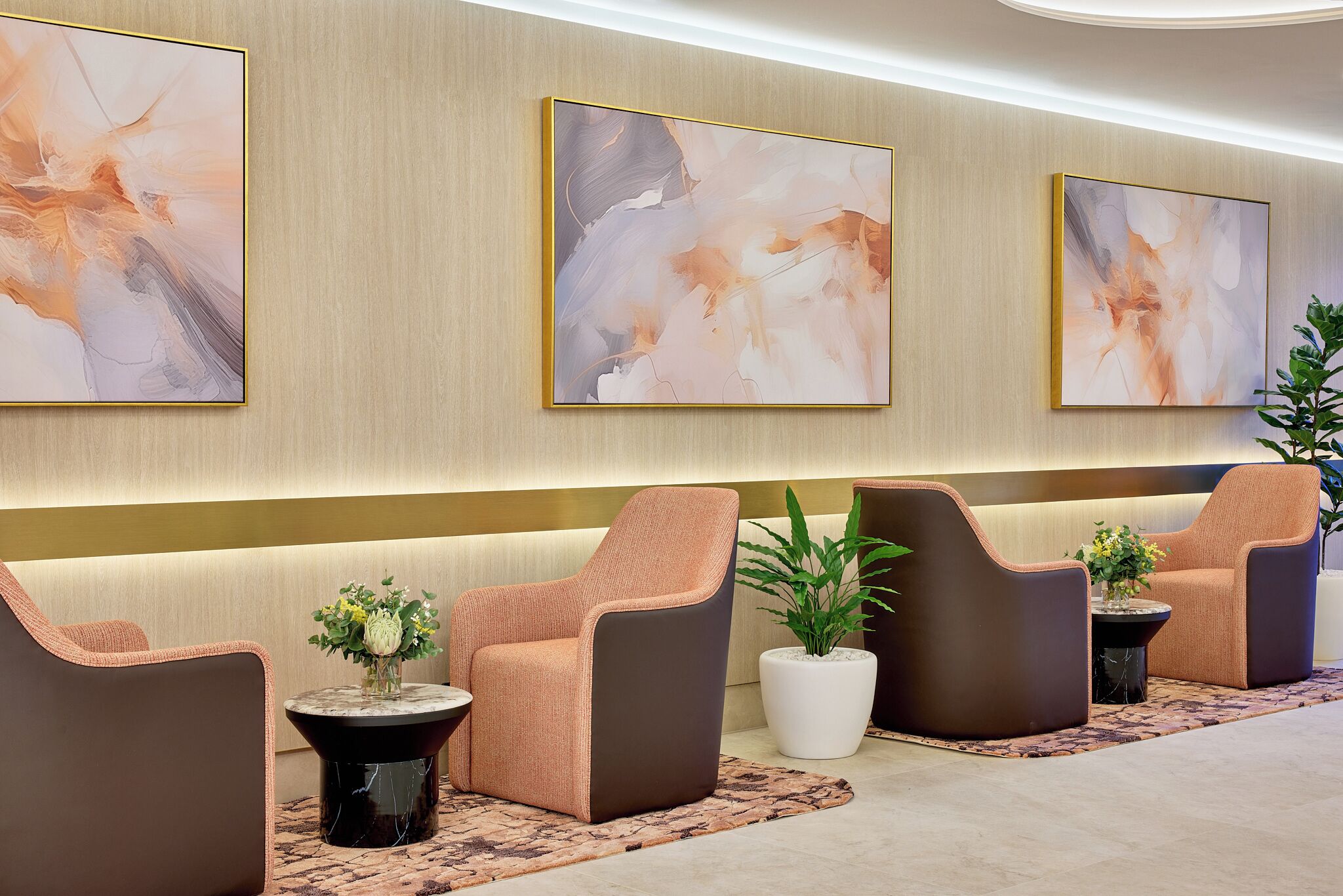 A lobby with abstract art, seating, and potted plants.