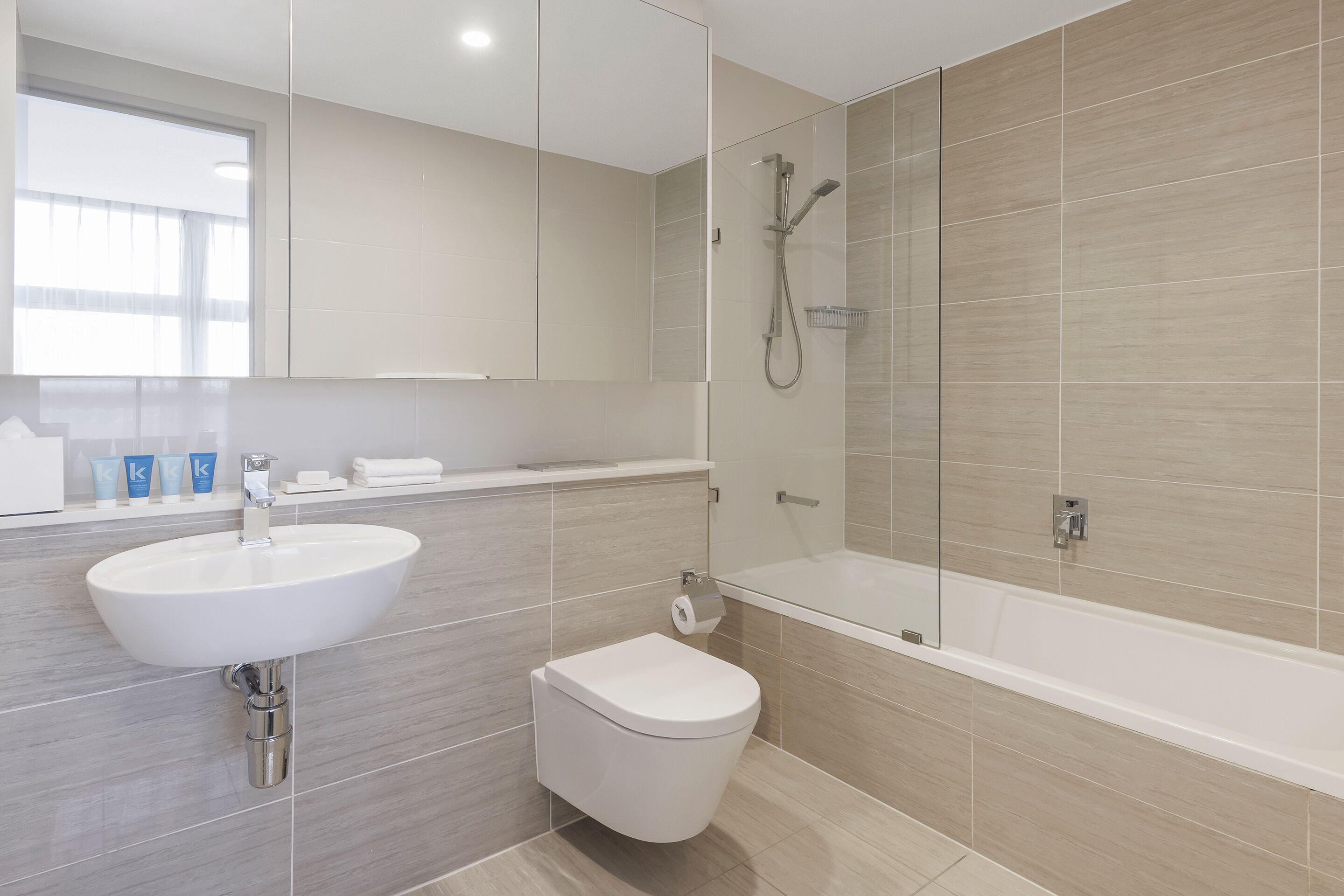 A modern bathroom with a sink, toilet, and shower.