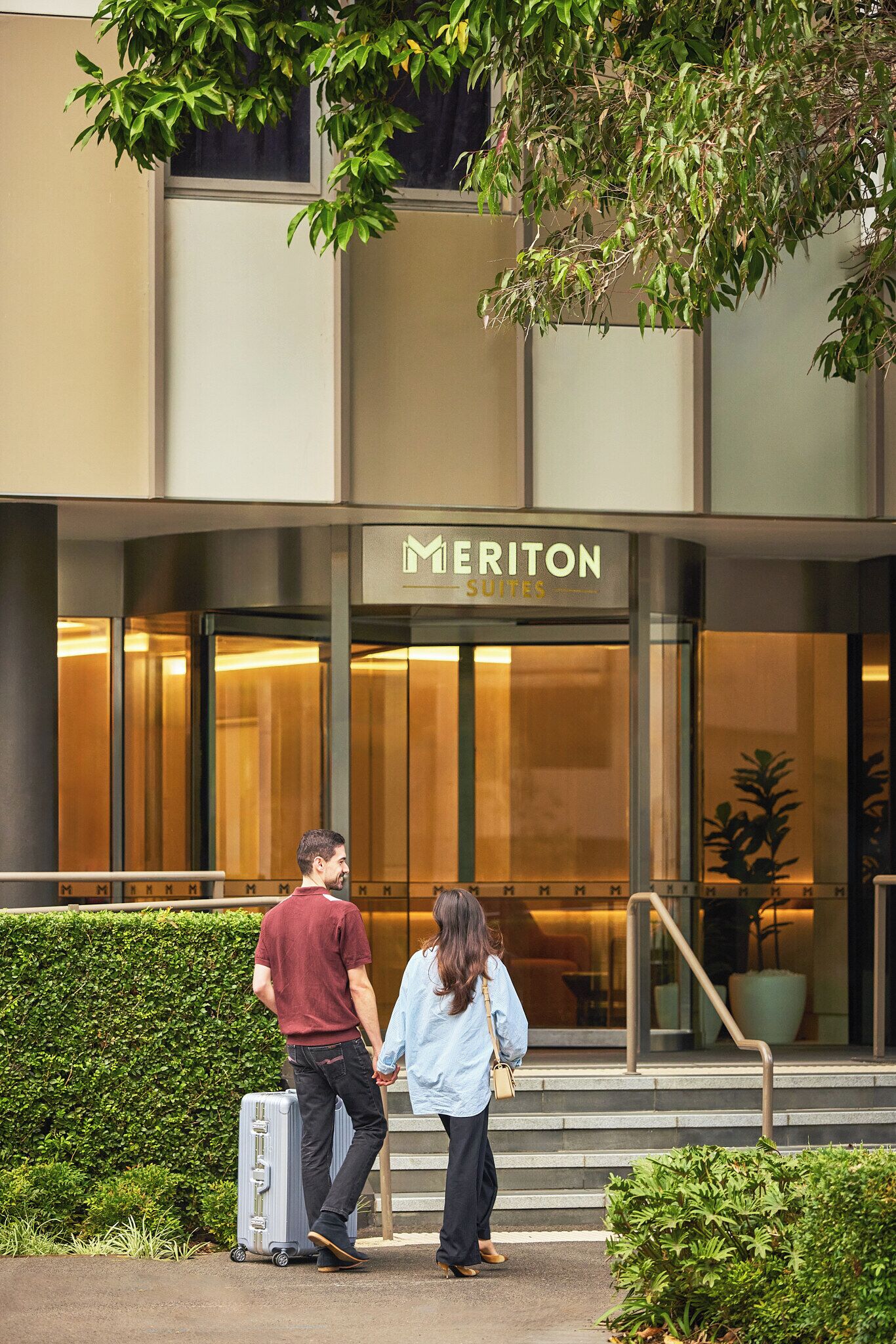 A hotel entrance with a sign reading 'MERITON SUITES.'